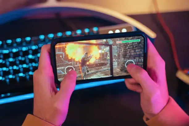 hands playing a game on a mobile phone for mobile gaming