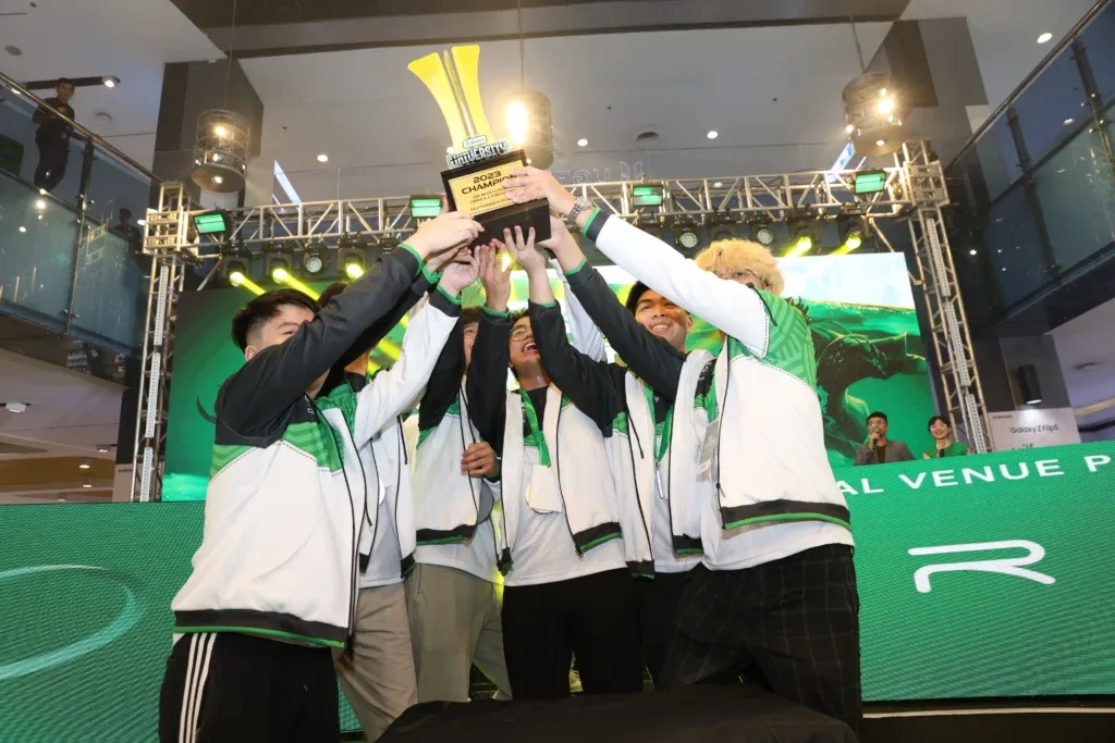 team of e-sports players holding a trophy on a stage for Smart’s University Clash Tournament