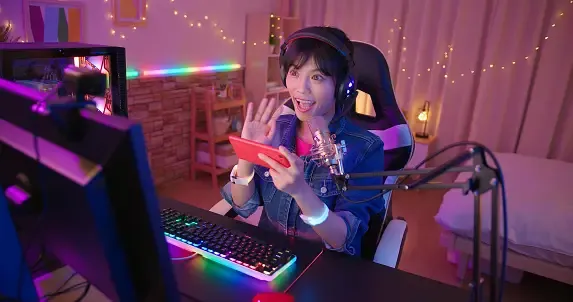 woman in a blue jacket sitting in front desk with a led keyboard