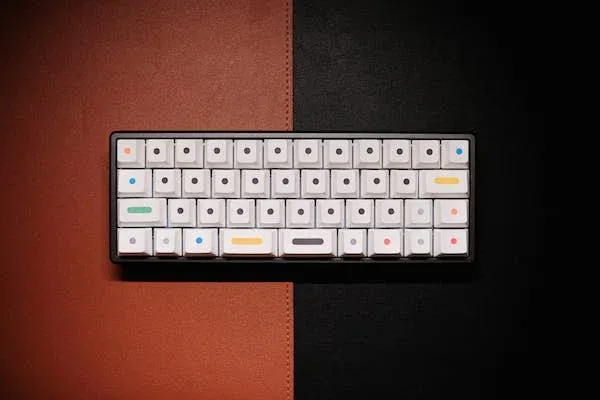 white wireless mechanical keyboard on a brown and black table